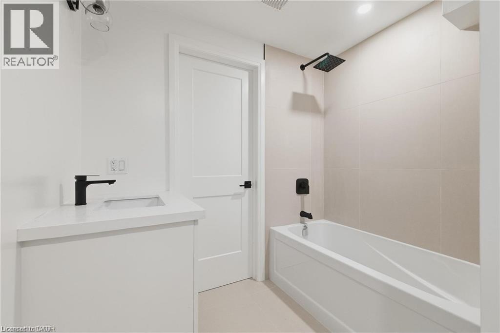 White vanity with a single-basin sink and a matte black faucet - 36 Elliott Street Unit# 1, Cambridge, ON