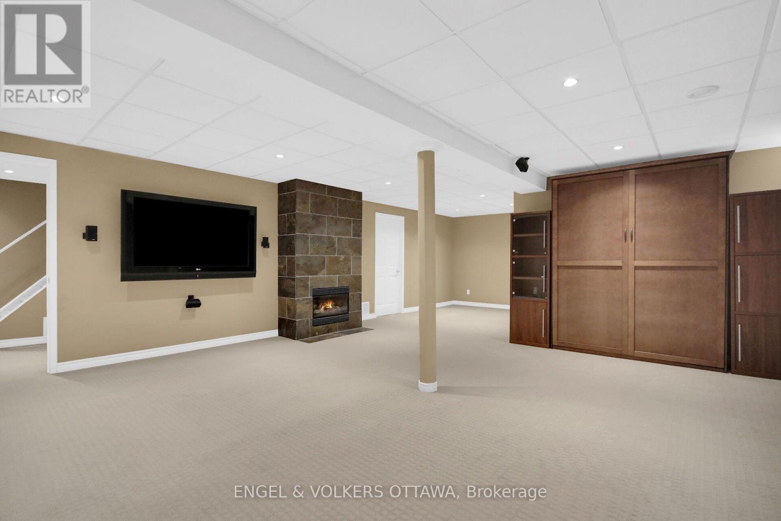 Lower level living area with gas fireplace. - 24 Tammela Court, Ottawa, ON