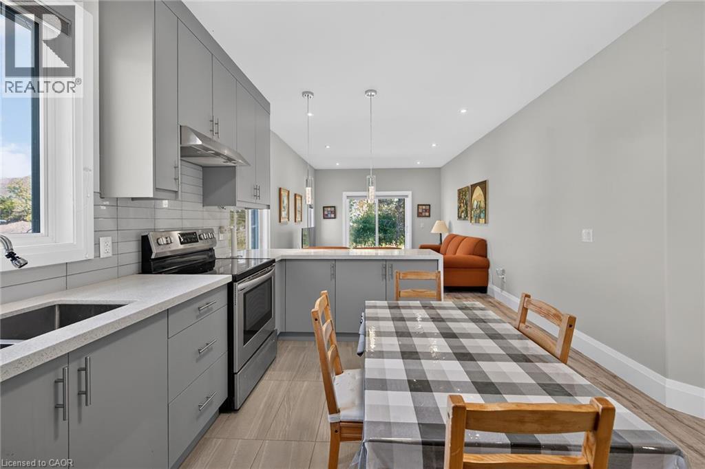 Kitchen featuring grey cabinetry, stainless steel appliances, light-toned countertops, and a tile backsplash - 41 Eleanor Avenue, Hamilton, ON
