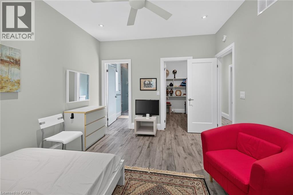 Light gray wall paint, wood-finish flooring, recessed ceiling lights, white ceiling fan, and white doors - 41 Eleanor Avenue, Hamilton, ON
