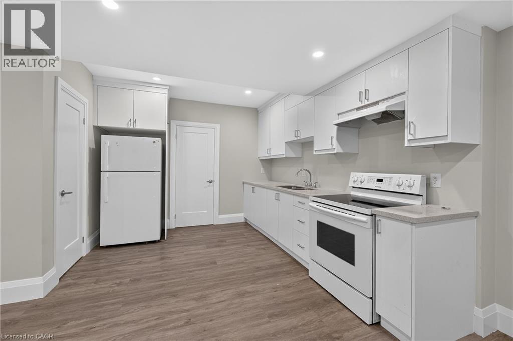 White cabinetry, white appliances, wood-finish flooring, recessed lighting, and light-toned countertops - 41 Eleanor Avenue, Hamilton, ON