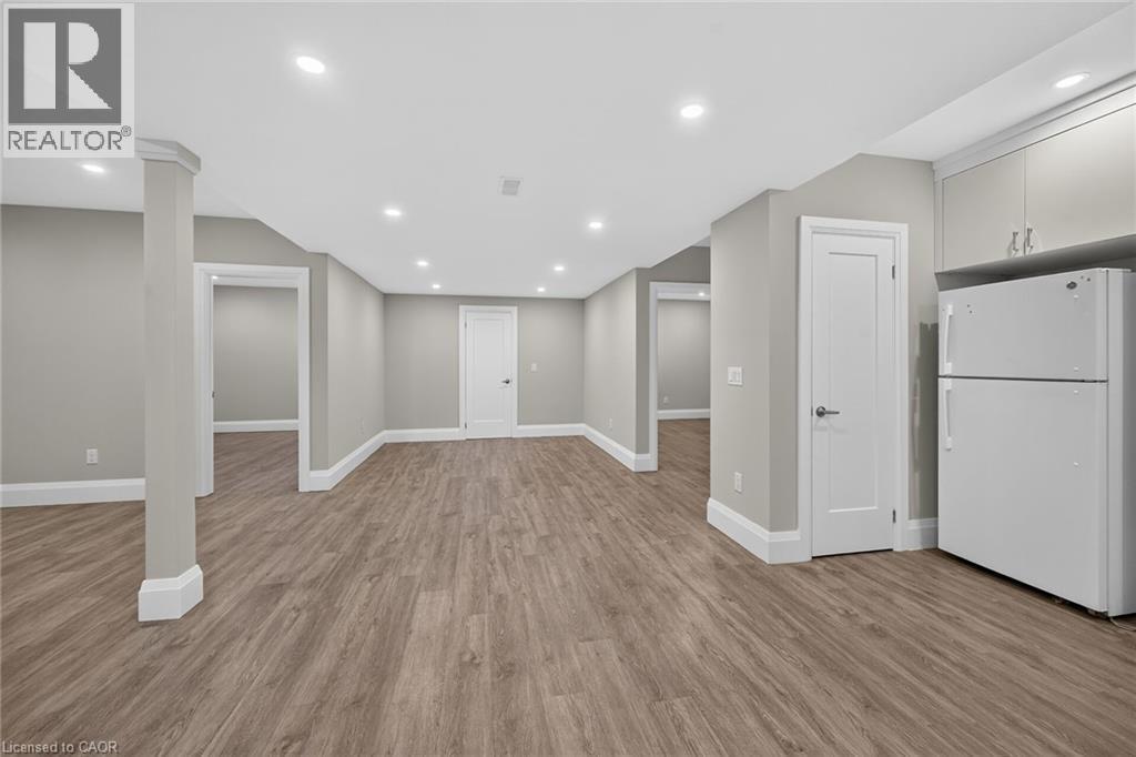 Spacious room with wood-finish flooring, recessed lighting, neutral wall tones, and white trim - 41 Eleanor Avenue, Hamilton, ON
