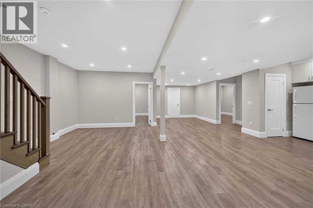 Spacious room featuring recessed lighting, wood-finish flooring, white trim, and multiple doorways - 41 Eleanor Avenue, Hamilton, ON