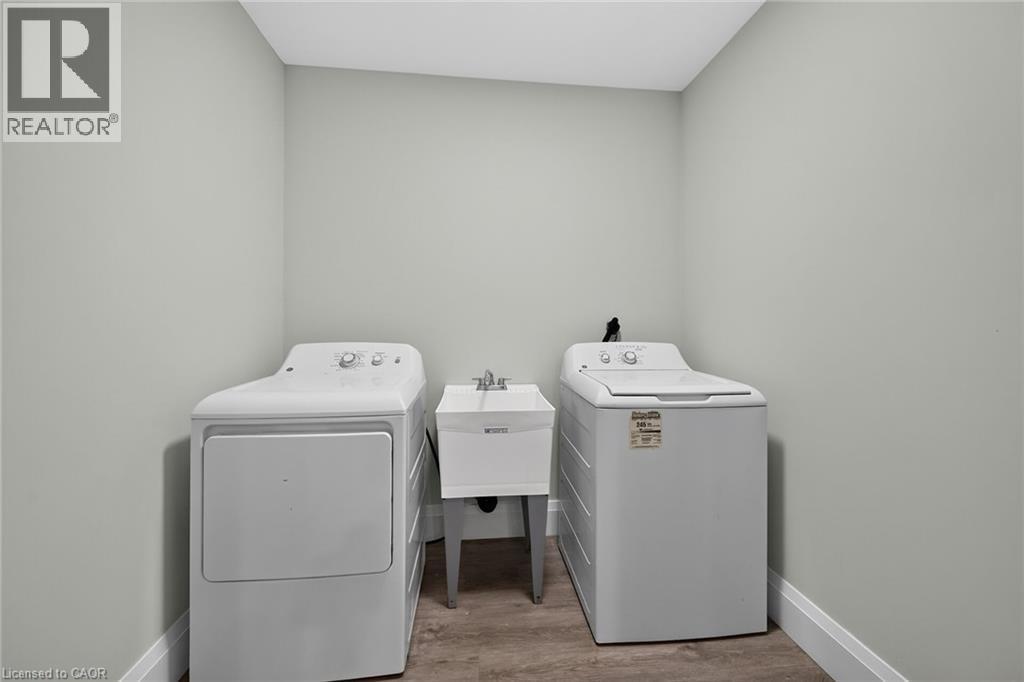Dedicated laundry area with a utility sink and wood-finish flooring - 41 Eleanor Avenue, Hamilton, ON