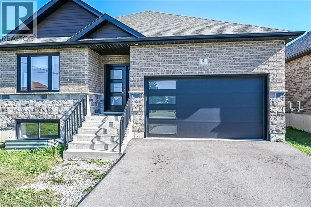 Brick and stone facade with dark framed windows, a contemporary entry door, and an attached single-car garage - 41 Eleanor Avenue, Hamilton, ON