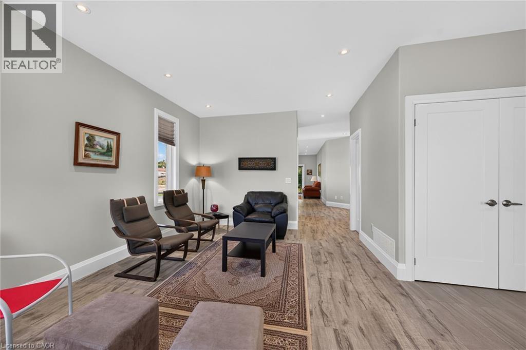 Recessed ceiling lighting, durable wood-finish flooring, white trim, white paneled doors, and a window with blinds - 41 Eleanor Avenue, Hamilton, ON