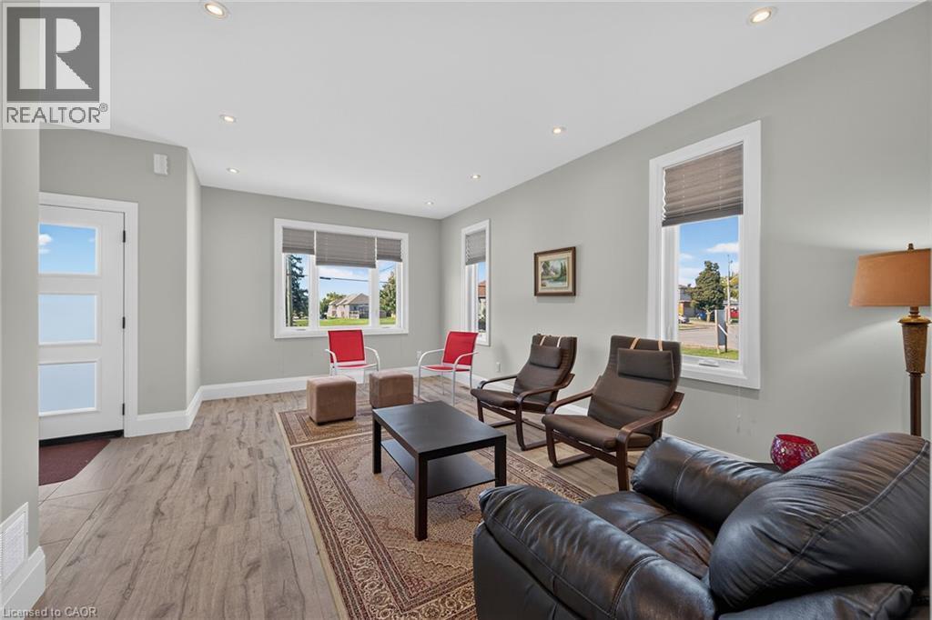 Recessed ceiling lighting, wood-finish flooring, white trim, multiple windows with blinds, and a paneled entry door - 41 Eleanor Avenue, Hamilton, ON