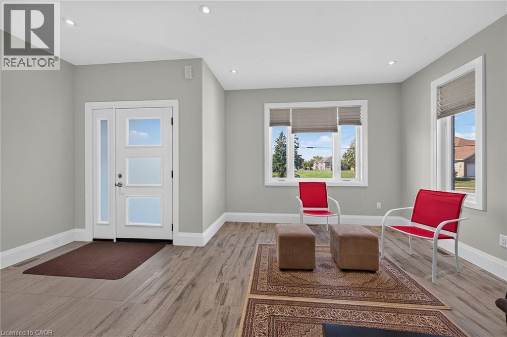 Recessed lighting, wood-finish flooring, white trim, modern entry door with frosted glass panels, and multiple windows - 41 Eleanor Avenue, Hamilton, ON