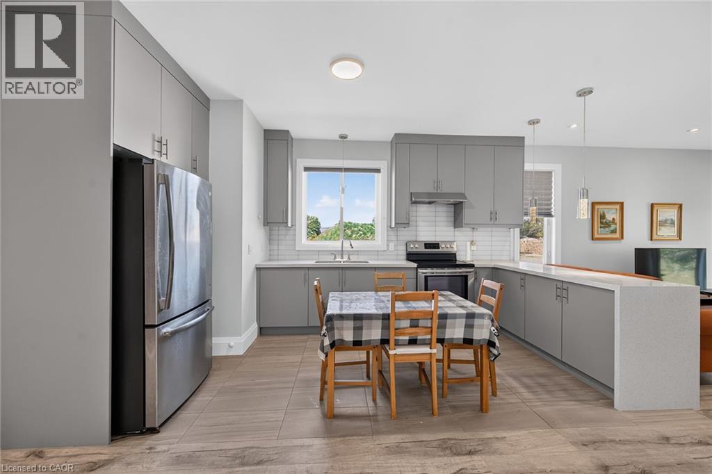 Kitchen featuring light gray cabinetry, stainless steel appliances, white subway tile backsplash, and light-toned countertops - 41 Eleanor Avenue, Hamilton, ON
