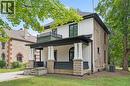 Stucco and stone exterior with a covered porch featuring decorative pillars and a second-story balcony with wrought iron railing - 245 Lowther Street S, Cambridge, ON 
