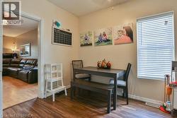 Wood-finish flooring throughout, with a window featuring horizontal blinds -