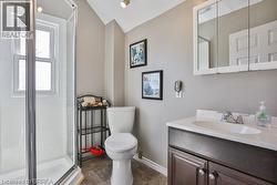 Glass-enclosed shower with a window, white vanity with an integrated sink, dark wood-finish cabinetry, and a mirrored medicine cabinet -