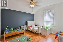 Recessed window with horizontal blinds, sloped ceiling, wood-finish flooring, and ceiling fan with integrated lighting -