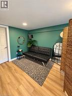 Wood-finish flooring with recessed lighting, complemented by a white paneled door -