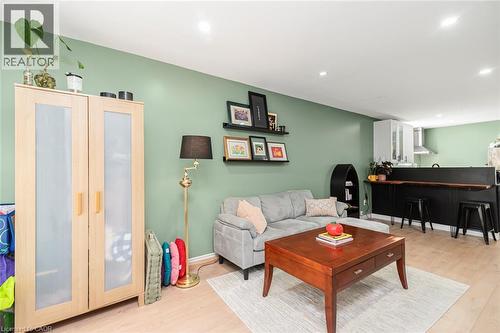Recessed lighting, wood-finish flooring, and a kitchen featuring white cabinetry and a stainless steel range hood - 29 Wexford Avenue N, Hamilton, ON 