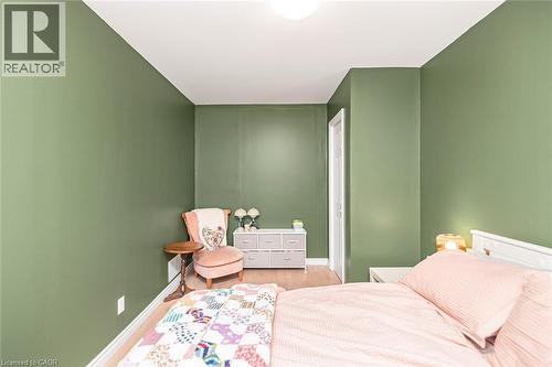 Green-painted interior walls, light wood-finish flooring, white trim, and a white ceiling - 29 Wexford Avenue N, Hamilton, ON 