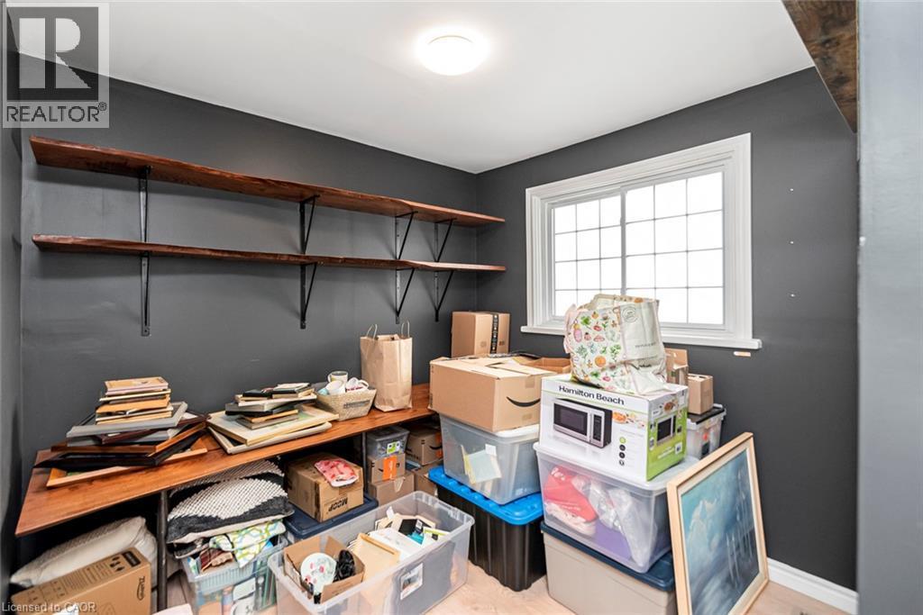 Built-in wood-finish shelving with dark metal brackets, white-trimmed window, and recessed ceiling light - 29 Wexford Avenue N, Hamilton, ON
