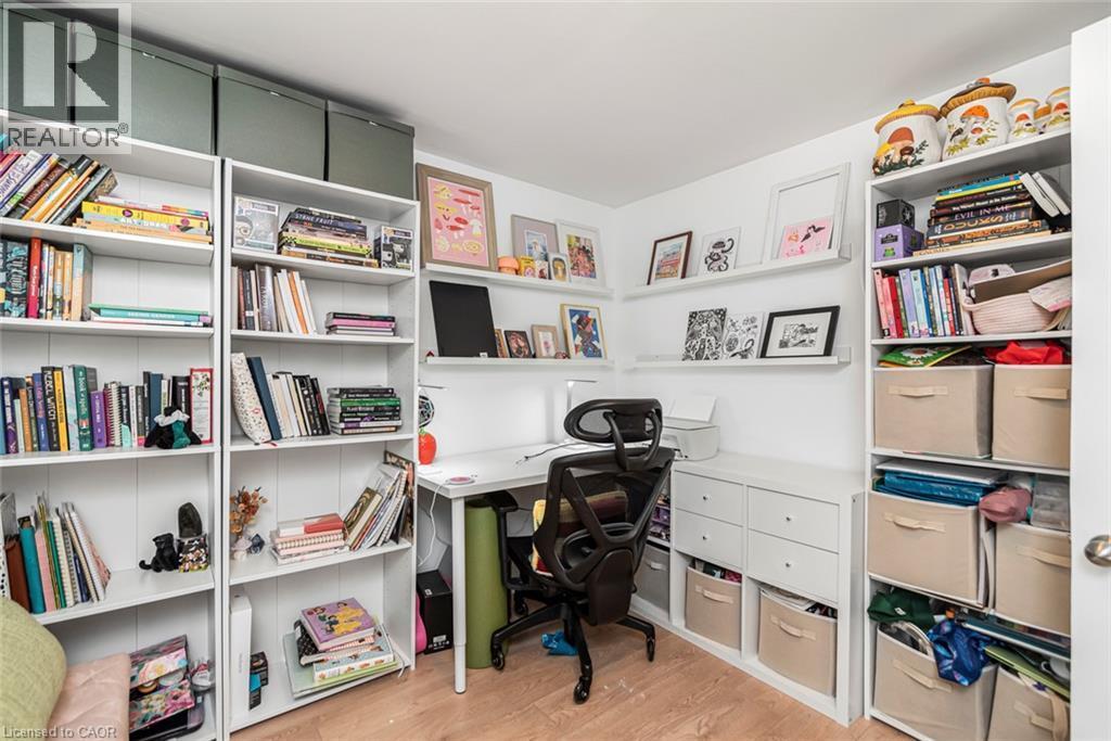 Built-in shelving units with ample storage, integrated desk area, and wood-finish flooring - 29 Wexford Avenue N, Hamilton, ON