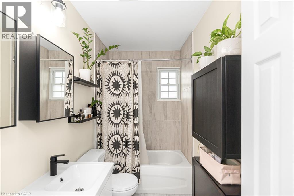 Modern vanity with a rectangular sink and matte black faucet - 29 Wexford Avenue N, Hamilton, ON