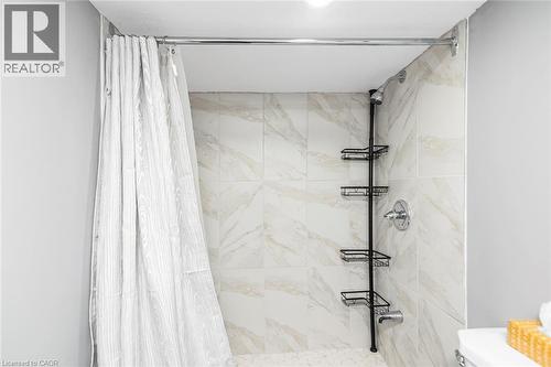 Shower featuring tile surround, chrome fixtures, and recessed lighting - 29 Wexford Avenue N, Hamilton, ON 