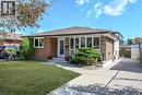 Brick exterior with a brown shingle roof, concrete driveway, and front entryway with a white door - 331 East 17Th Street, Hamilton, ON 