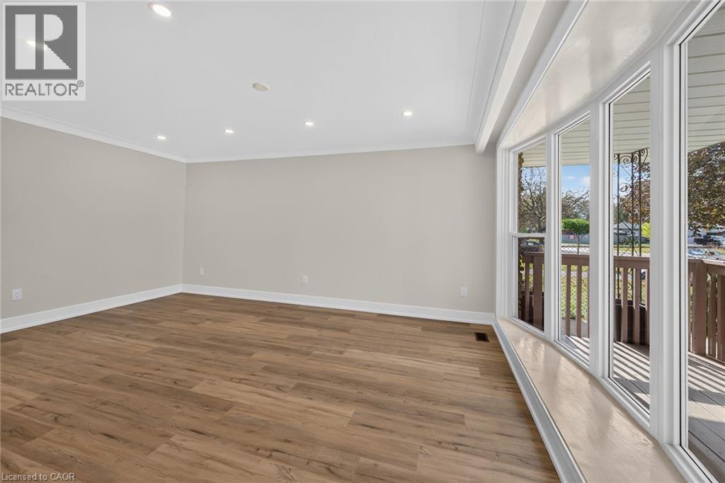 Recessed lighting, wood-finish flooring, white crown molding, white baseboards, and a large bay window - 331 East 17Th Street, Hamilton, ON