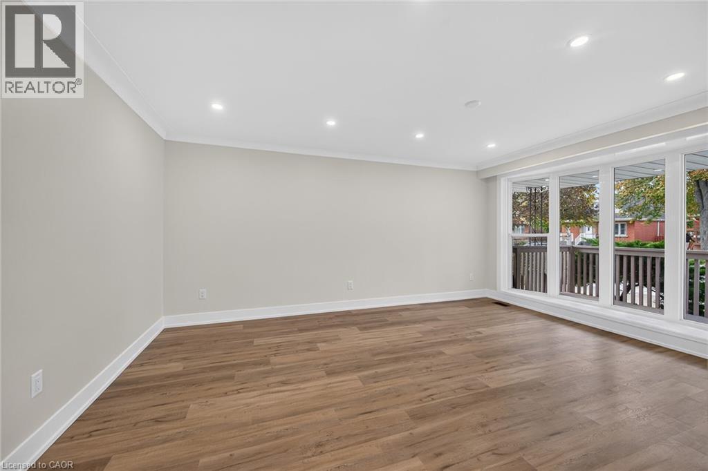 Hardwood-style flooring, white crown molding, recessed lighting, and expansive windows - 331 East 17Th Street, Hamilton, ON