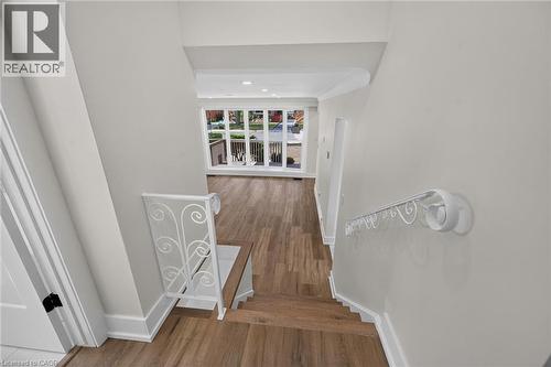 Wood-finish flooring, white wrought iron railing, white trim, recessed lighting, and large windows - 331 East 17Th Street, Hamilton, ON 