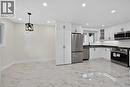 Kitchen featuring white cabinetry, stainless steel appliances, dark countertops, and white tile flooring - 331 East 17Th Street, Hamilton, ON 