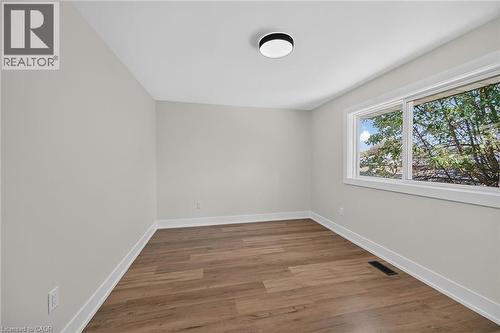 Light-toned wall finish, wood-finish flooring, white trim, recessed lighting, and a large window - 331 East 17Th Street, Hamilton, ON 