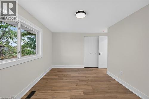 Wood-finish flooring, white trim, and a modern flush-mount ceiling fixture - 331 East 17Th Street, Hamilton, ON 