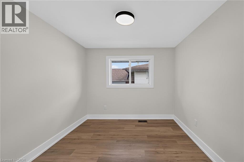 Recessed ceiling light fixture, wood-finish flooring, white trim, and a window with white framing - 331 East 17Th Street, Hamilton, ON