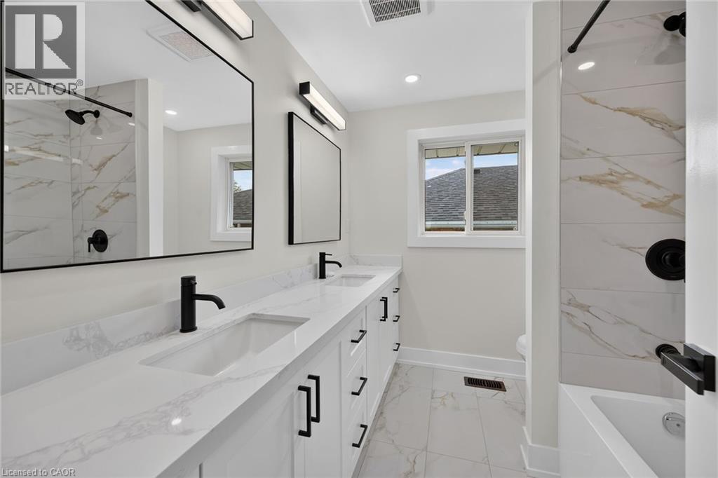 Dual vanity with white countertops, integrated sinks, and black fixtures - 331 East 17Th Street, Hamilton, ON