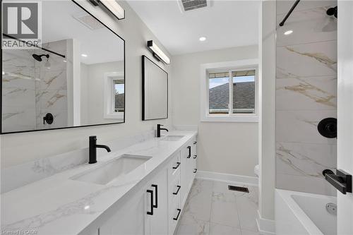 Dual vanity with white countertops, integrated sinks, and black fixtures - 331 East 17Th Street, Hamilton, ON 