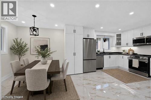 White shaker cabinetry paired with stainless steel appliances and black countertops - 331 East 17Th Street, Hamilton, ON 
