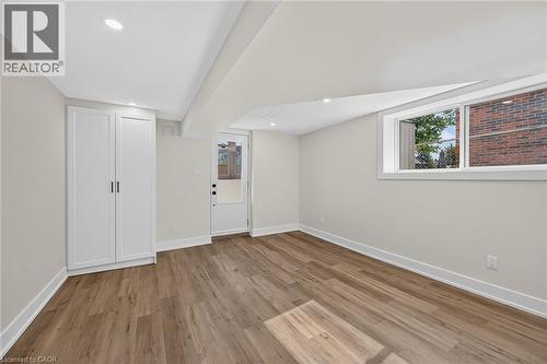 Wood-finish flooring, recessed lighting, white built-in cabinetry, modern white trim, and an egress window - 331 East 17Th Street, Hamilton, ON 