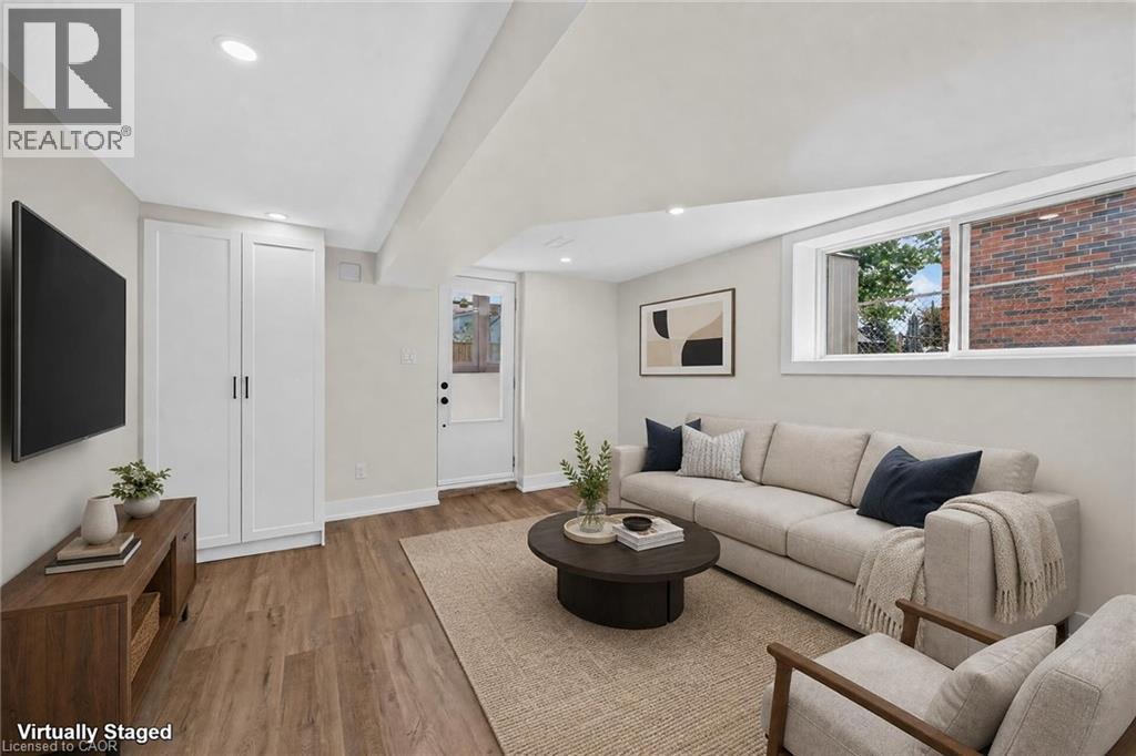 Recessed lighting, wood-finish flooring, built-in white cabinetry, and a white exterior door - 331 East 17Th Street, Hamilton, ON