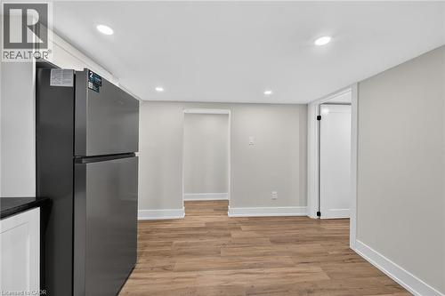Stainless steel refrigerator, recessed ceiling lighting, wood-finish flooring, white baseboards, and white interior doors - 331 East 17Th Street, Hamilton, ON 