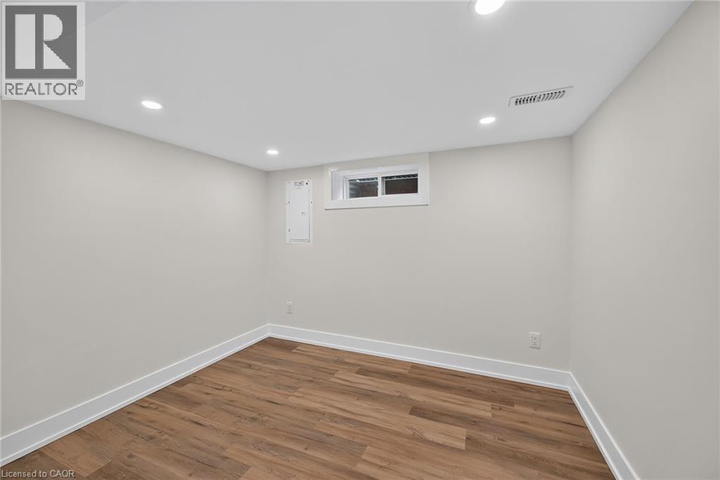Recessed ceiling lighting, wood-finish flooring, light-colored walls, white trim, and a high window - 331 East 17Th Street, Hamilton, ON
