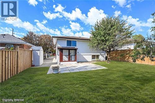 Expansive backyard featuring a lush lawn, privacy fencing, and an outdoor patio area - 331 East 17Th Street, Hamilton, ON 