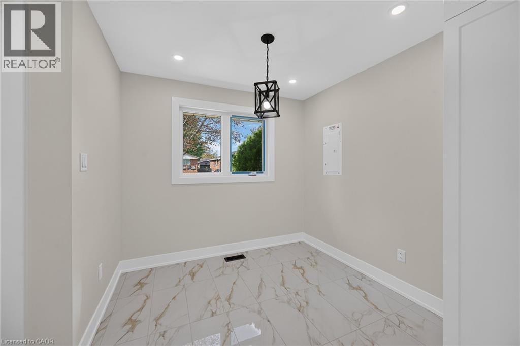 Recessed ceiling lighting, a contemporary black lantern pendant light, white trim, and light-toned walls - 331 East 17Th Street, Hamilton, ON