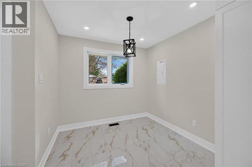 Recessed ceiling lighting, a contemporary black lantern pendant light, white trim, and light-toned walls - 331 East 17Th Street, Hamilton, ON 