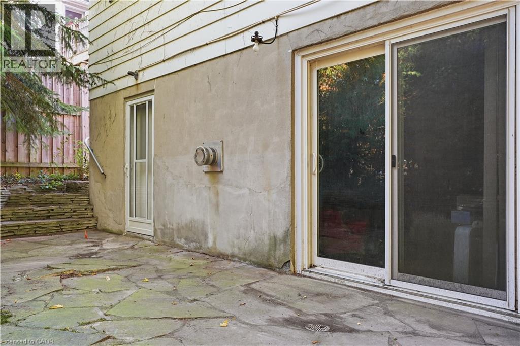 Stonework patio with a sliding glass door entry and an additional side entry door - 12 Hill Street, Kitchener, ON