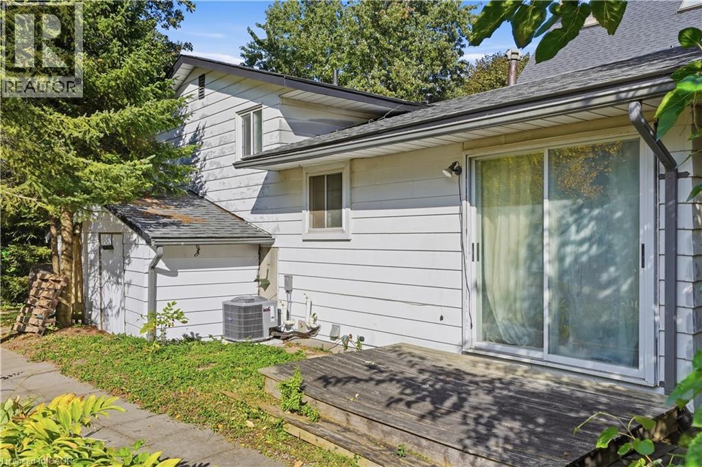 Exterior featuring white siding, a wooden deck, and a sliding glass door - 12 Hill Street, Kitchener, ON