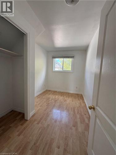 Wood-finish flooring, white walls, and a window with blinds - 1087 Cannon Street E, Hamilton, ON 