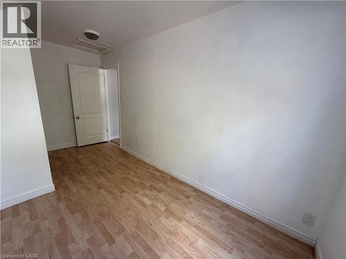 Wood-finish flooring with white baseboards - 1087 Cannon Street E, Hamilton, ON 