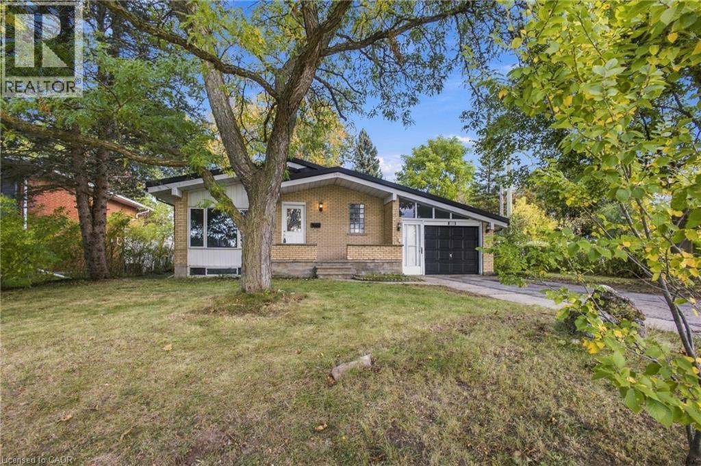 Brick exterior with a peaked roofline, front-facing garage, and a concrete driveway - 246 Hillcrest Road, Cambridge, ON