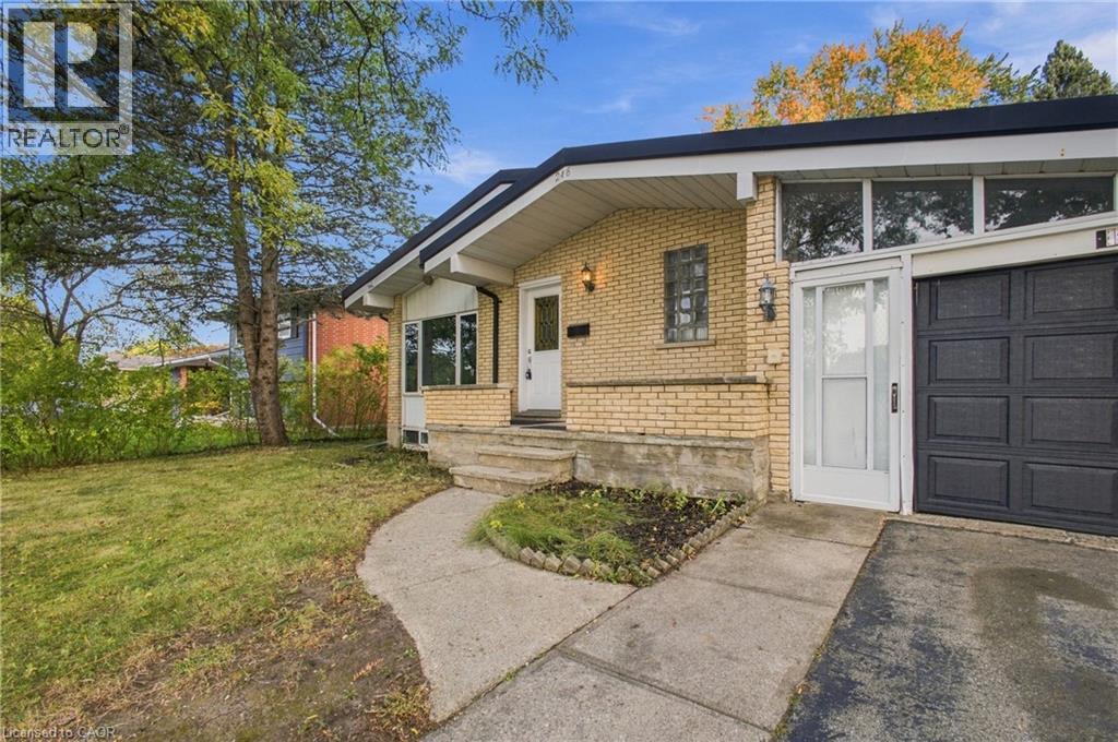 Brick exterior with a prominent front entrance, an integrated garage, a concrete pathway, and a grassy front yard - 246 Hillcrest Road, Cambridge, ON