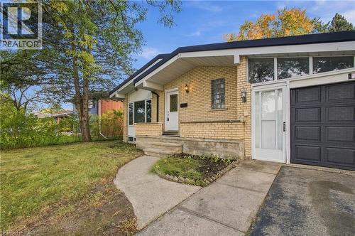 Brick exterior with a prominent front entrance, an integrated garage, a concrete pathway, and a grassy front yard - 246 Hillcrest Road, Cambridge, ON 