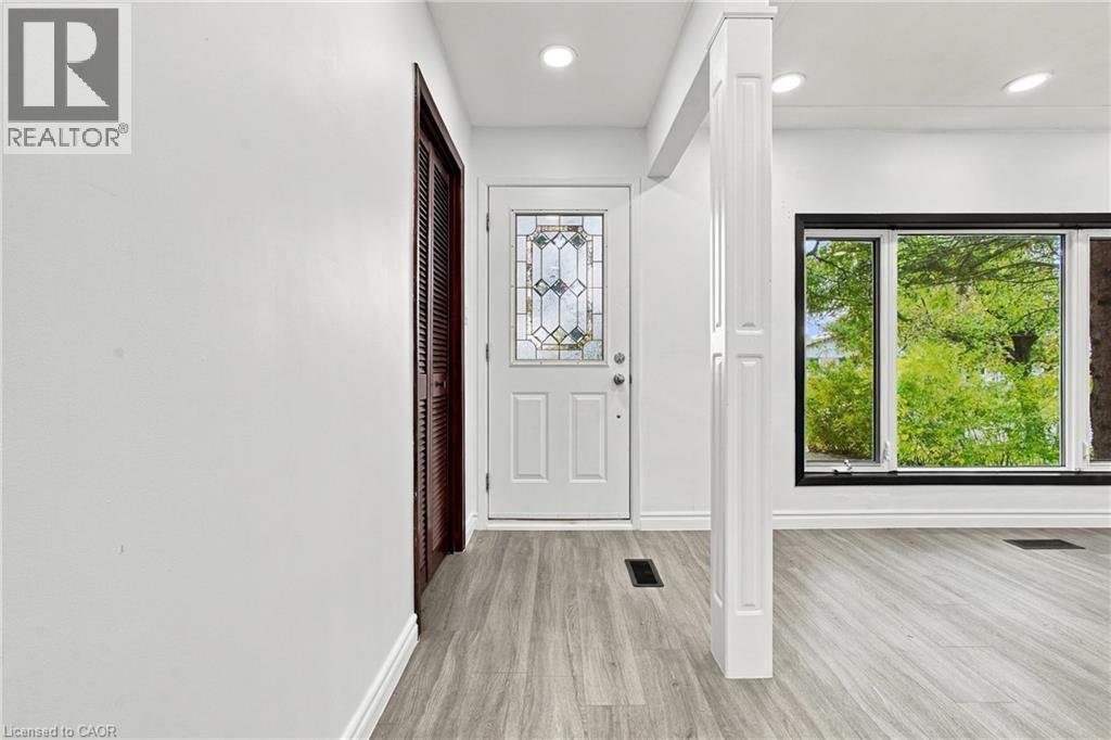 Entryway featuring a decorative glass front door, recessed lighting, and wood-finish flooring - 246 Hillcrest Road, Cambridge, ON